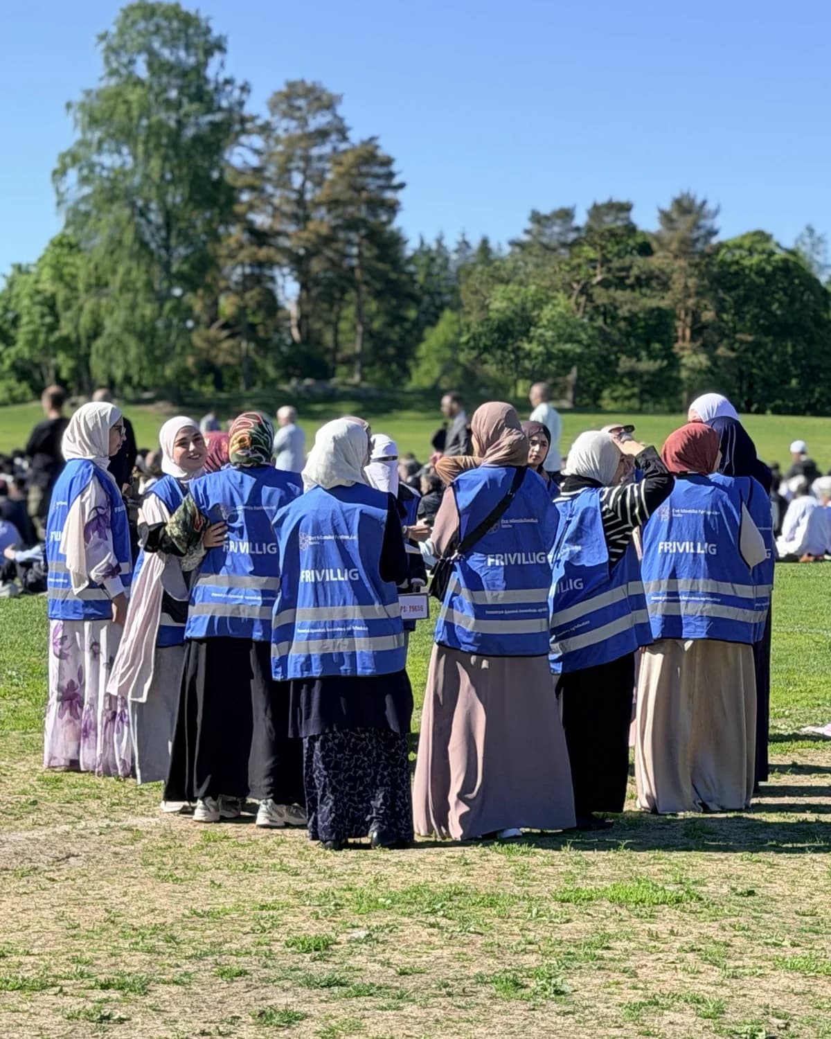 Rabita volunteers in blue FRIVILLIG vests at the outdoor Eid prayer